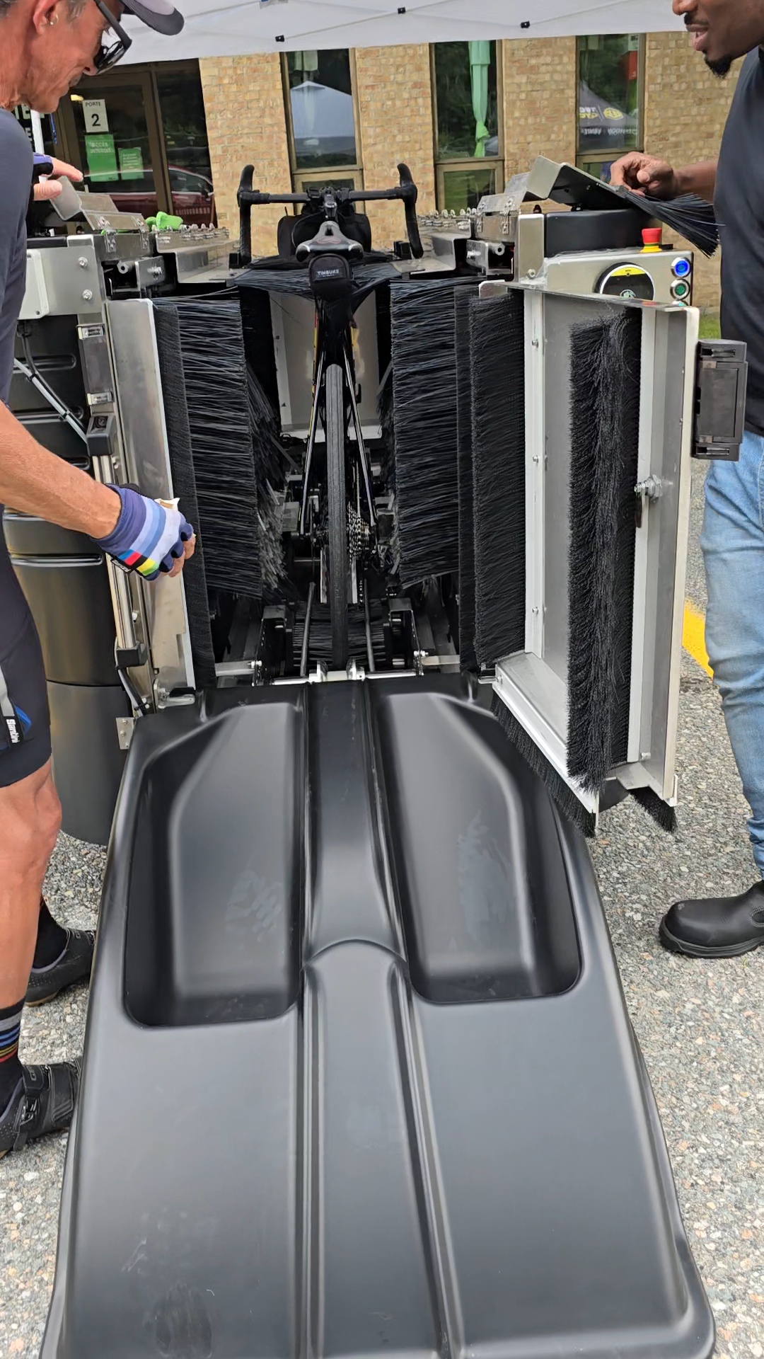 Vélo de route entre les brosses de la machine cycleWASH, équipe Velonette en opération